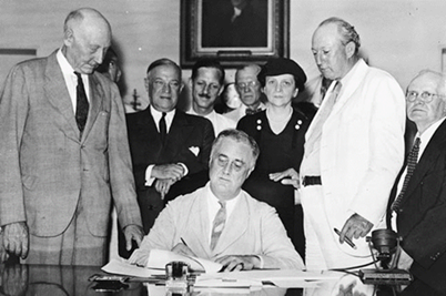 A black and white picture of the man signing the document